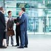 Businessmen and woman standing, discussing business
